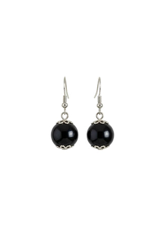 A pair of handmade dangle earrings featuring glossy black glass beads with silver filigree cutouts at the bottom, suspended from silver-toned fishhook wires, displayed on a plain off-white surface.