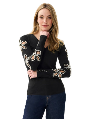 Woman wearing a black sweater with floral patterns on a white background