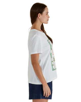 Woman wearing a white t-shirt with a graphic design on a beige background