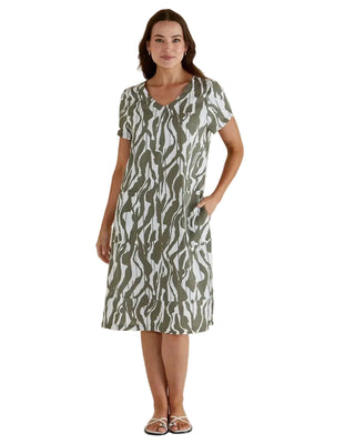 Woman wearing a patterned dress against a plain background