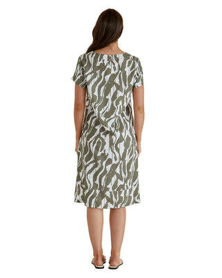 Woman wearing a patterned dress against a beige background