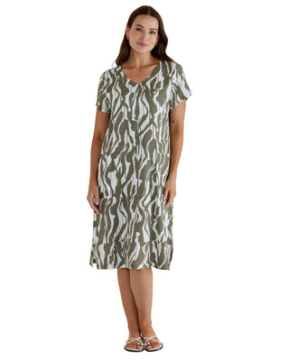 Woman wearing a patterned dress against a plain background
