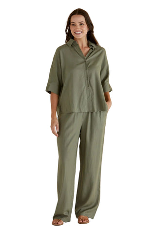 Woman wearing a green outfit against a beige background