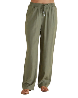 Olive green pants worn by a person on a beige background