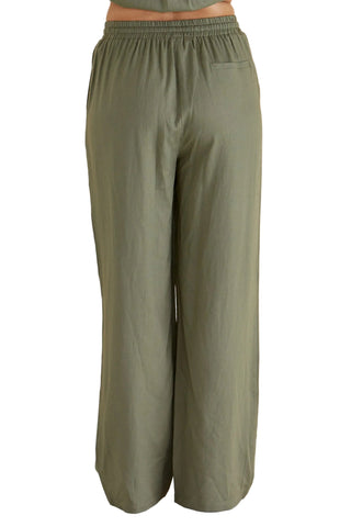 Green wide-leg pants on a beige background