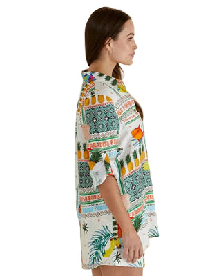 Woman wearing a colorful patterned shirt with a beige background