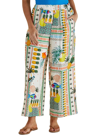 Person wearing colorful tropical print pants with a plain background