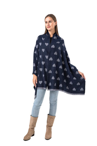 Woman wearing a navy blue poncho with heart patterns on a white background
