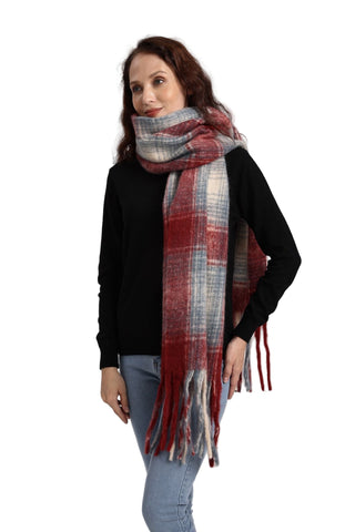 Woman wearing a plaid scarf with red, blue, and white pattern on a plain background