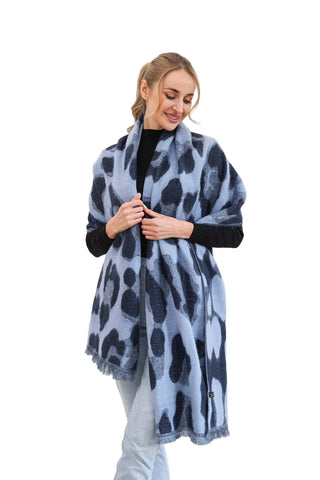 Woman wearing a blue leopard print scarf against a white background