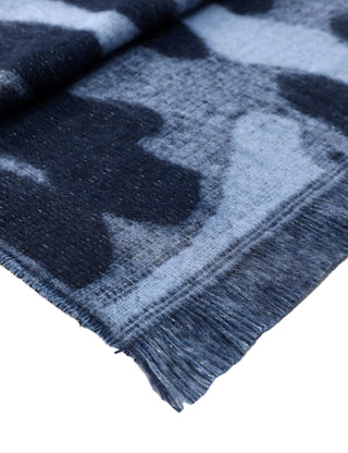 Close-up of a blue and gray plaid fabric with fringes on a white background