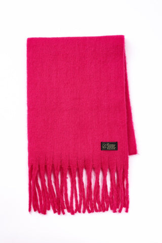 Pink scarf with fringes and a brand label on a white background