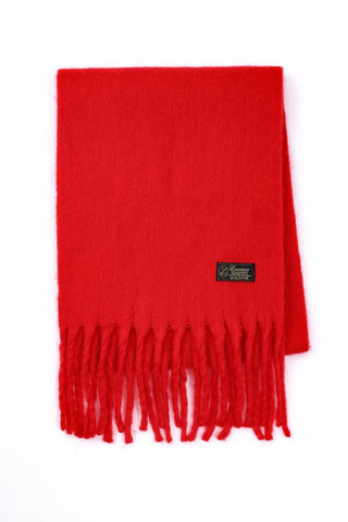 Red scarf with fringes and a brand label on a white background