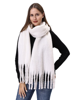 Woman wearing a white scarf with fringe on a plain background