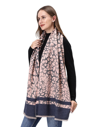 Woman wearing a leopard print scarf with a black top and blue jeans on a white background