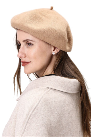 Woman wearing a beige beret and coat on a light gray background