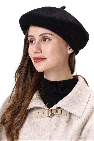 Woman wearing a black beret and beige coat against a white background