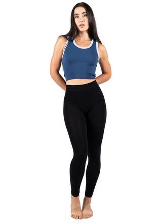 Woman wearing a blue tank top and black leggings on a white background