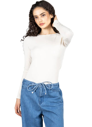 Woman wearing a white long-sleeve top and blue jeans on a white background
