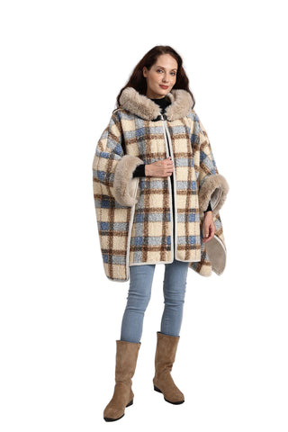 Woman wearing a checkered coat with fur trim on a plain background