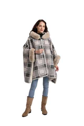 Woman wearing a plaid coat with fur trim on a white background