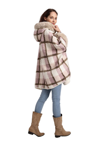 Woman wearing a plaid coat with a fur-lined hood on a plain background