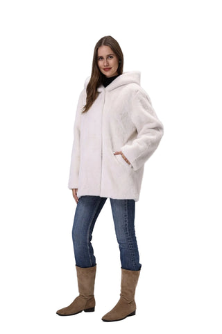 Woman wearing a white coat, blue jeans, and brown boots on a gray background