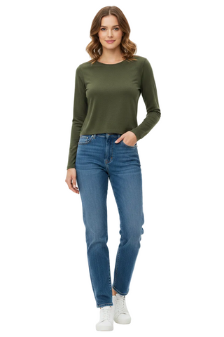 A woman modeling a fitted long-sleeve crewneck top in olive green, paired with blue jeans and white sneakers, against a plain white studio background.