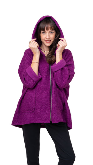 Woman wearing a purple hooded coat against a white background