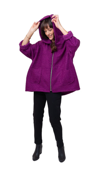 Person wearing a purple hooded jacket on a white background