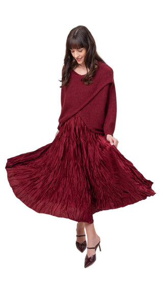 Woman wearing a burgundy dress with a shawl on a white background