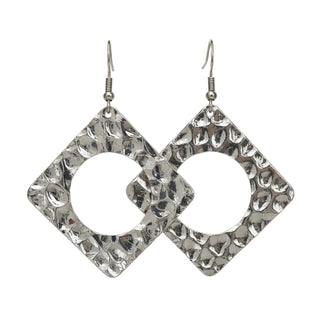 Square dangling earrings with a hammered silver-tone finish and a circular cutout, displayed on a black jewelry stand.