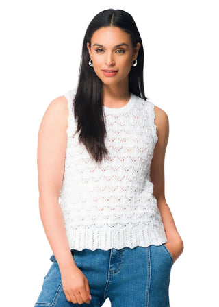 Woman wearing a white sleeveless top and blue jeans with flowers in the background