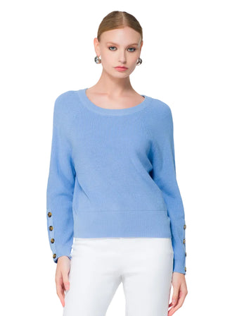 Woman wearing a light blue sweater with floral decorations in the background