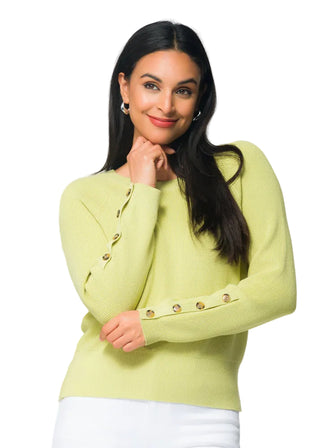 Woman wearing a light green sweater with floral background