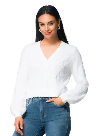 Woman wearing a white blouse and blue jeans with a white background