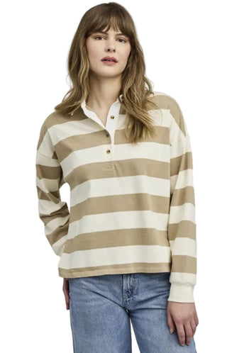 Woman wearing a striped long-sleeve shirt and jeans on a plain background