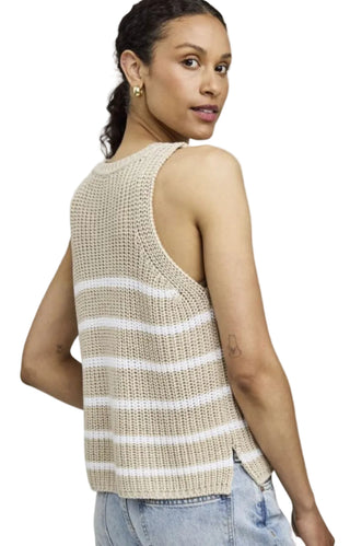Woman wearing a beige and white striped sleeveless top against a plain background