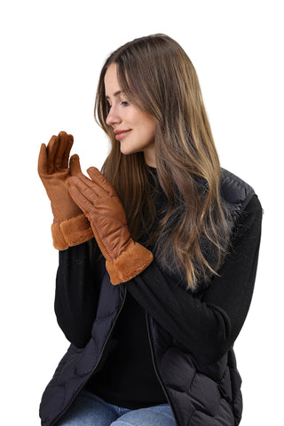 Woman wearing brown leather gloves with fur trim against a white background
