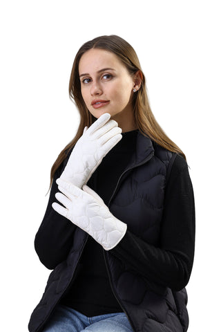 Woman wearing white gloves and a black coat against a light background