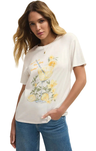 Woman wearing a white t-shirt with a lemon-themed design on a plain background