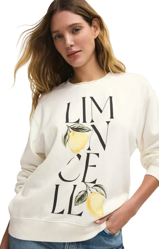 Woman wearing a white sweatshirt with lemon design and text