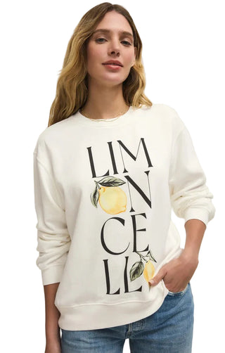 Woman wearing a white sweatshirt with lemon design and text on a plain background