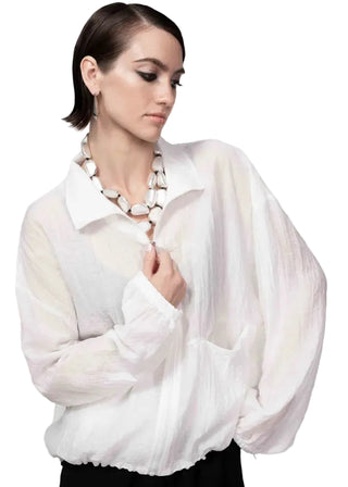 Woman wearing a white blouse with a plain background