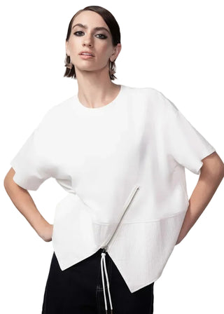 Woman wearing a white top with a zipper detail on a gray background