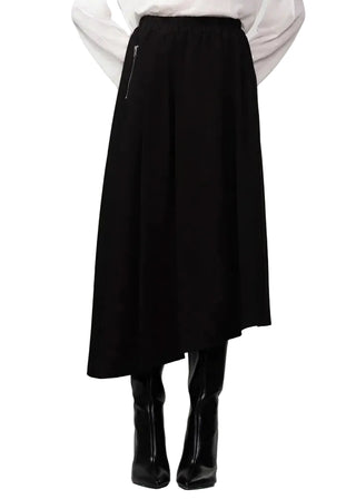 Person wearing a black skirt and black boots on a white background