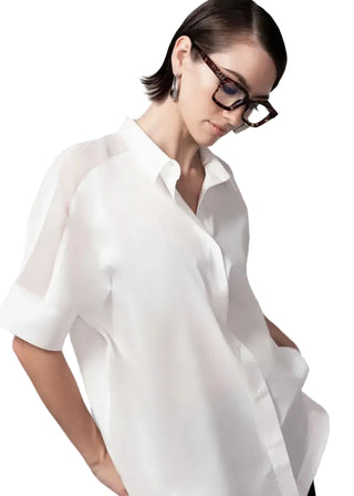 Woman wearing a white blouse with a plain background