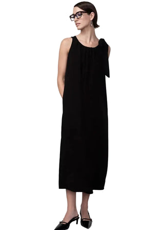 Woman wearing a black sleeveless dress against a white background