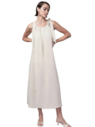 Woman wearing a white dress against a plain background
