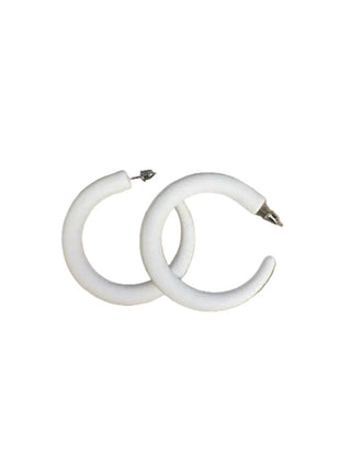 White hoop earrings on a brown cardboard background